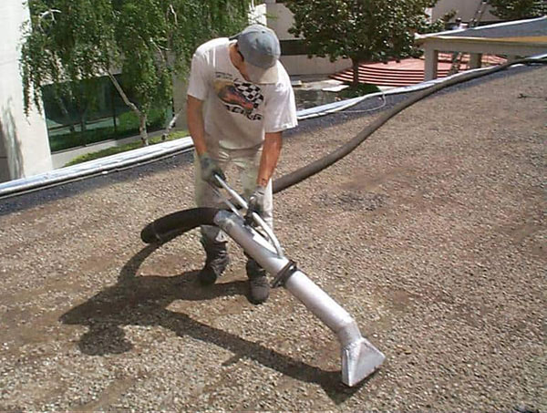 wet-vacuuming gravel off commercial roof