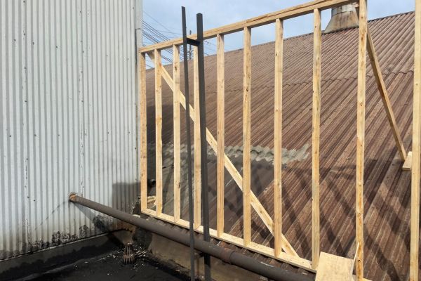 Plywood wall built to reroute water on Elyria Foundry's roof