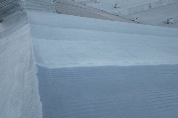 Base coat and top coat of coating being installed over a spray foam roof at Sharpsville Container in PA.