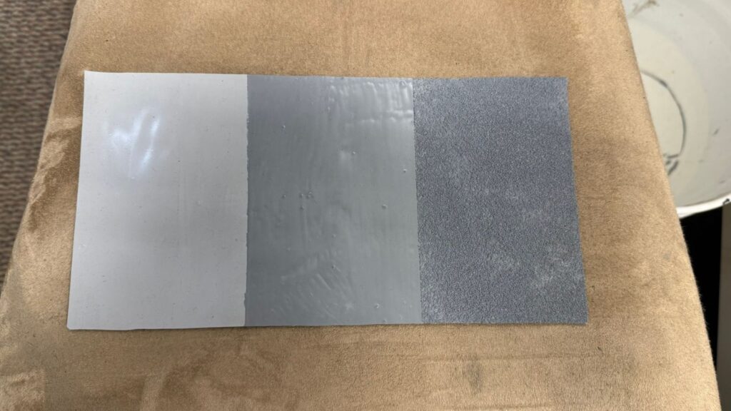 A sample of the basecoat, topcoat, and embedded granules over a rubber roof