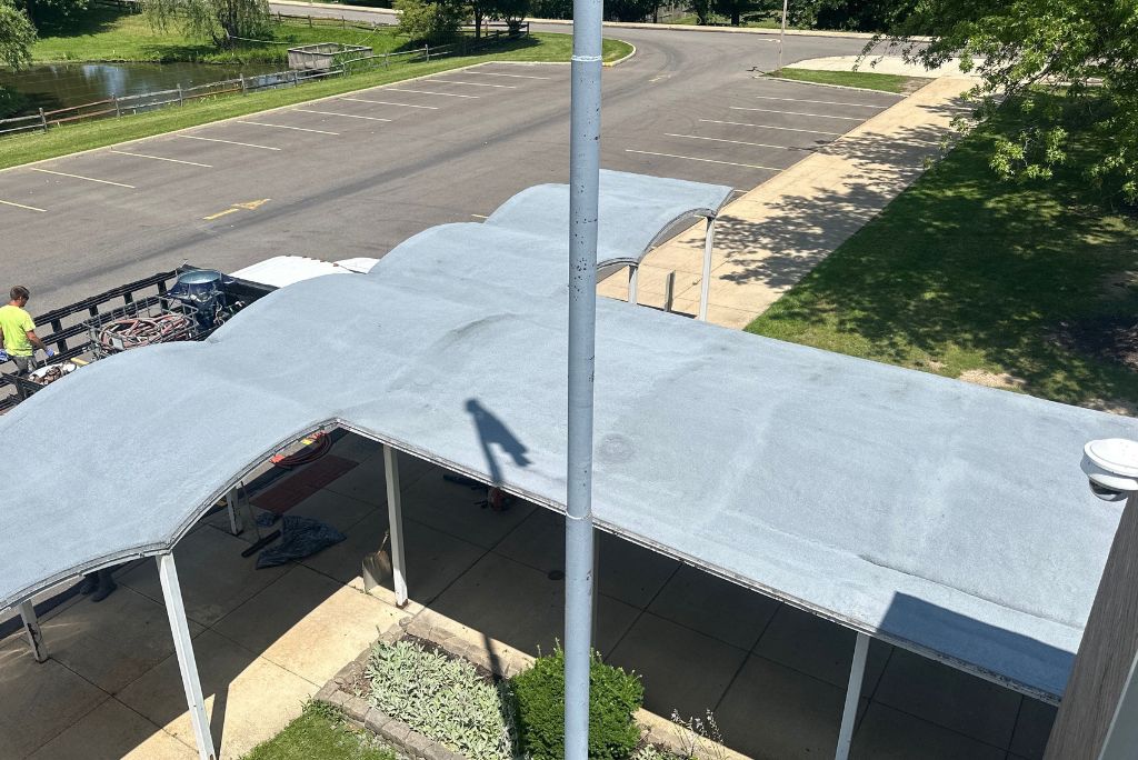 Commercial roofing installation in Parma Ohio - spray foam over smooth built up roof